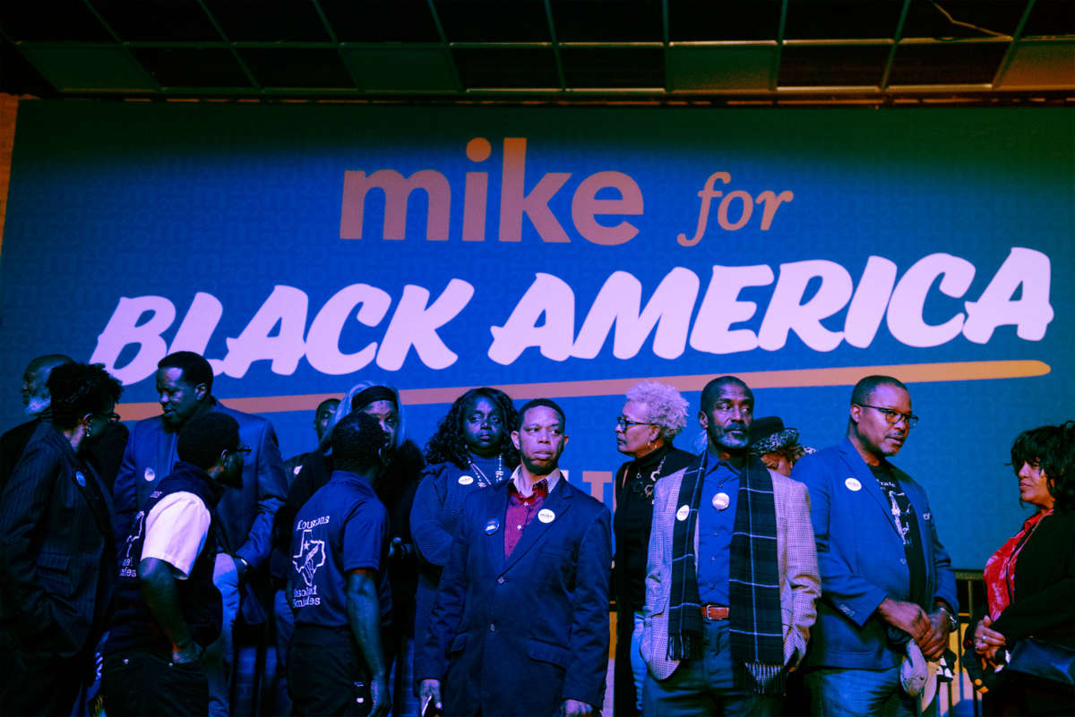 Black people line up under a sign reading "MIKE FOR BLACK AMERICA"