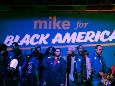 Black people line up under a sign reading "MIKE FOR BLACK AMERICA"