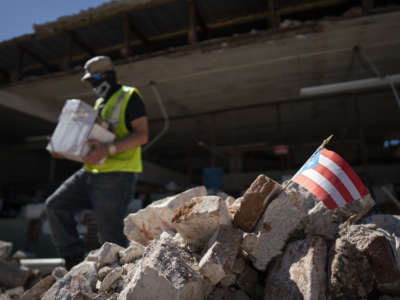 A Puerto Rican flag sits in a pile of rubble after a 6.4 earthquake hit just south of the island on January 7, 2020, in Gu&aacute;nica, Puerto Rico.