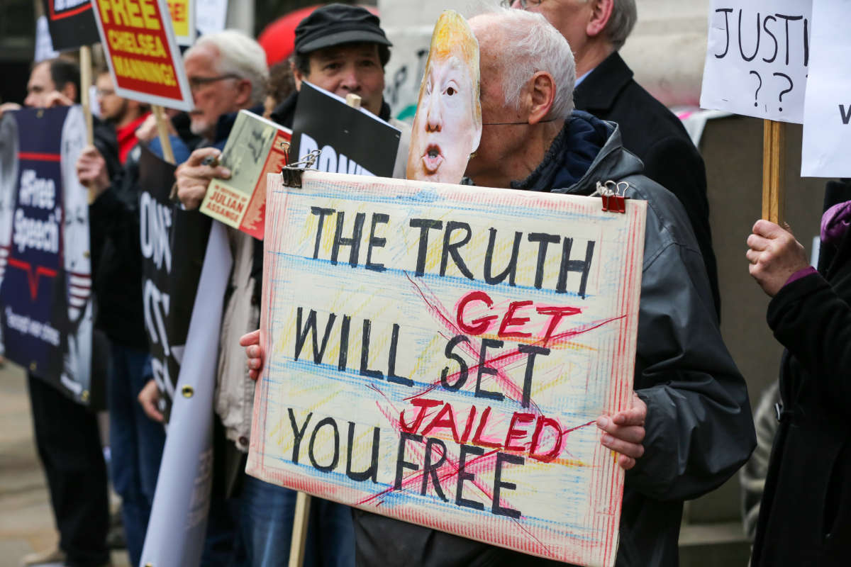 A supporter of Wikileaks Founder Julian Assange wearing a Donald Trump face mask holds a placard outside Australia House in central London against Assange's extradition to the United States where he will face espionage charges. The extradition trial hearing will be held at Woolwich Crown Court on February 24, 2020.