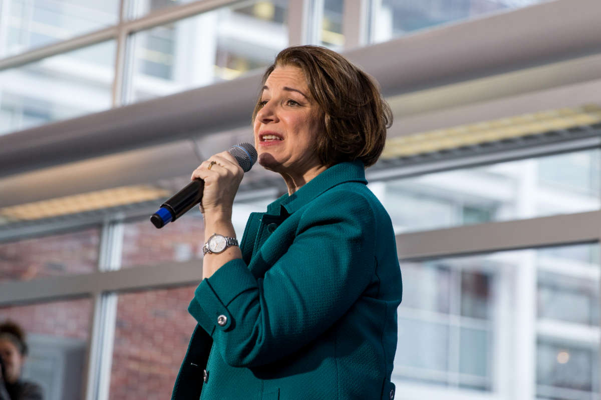 Amy Klobuchar speaks into a microphone during a campaign event