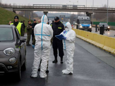 A picture taken on March 9, 2020, shows Polish police, border guards and medical staff with protective clothing proceeding to sanitary checks on drivers at Jedrzychowice border crossing, between Poland and Germany, in a measure to protect against the spread of the novel coronavirus.