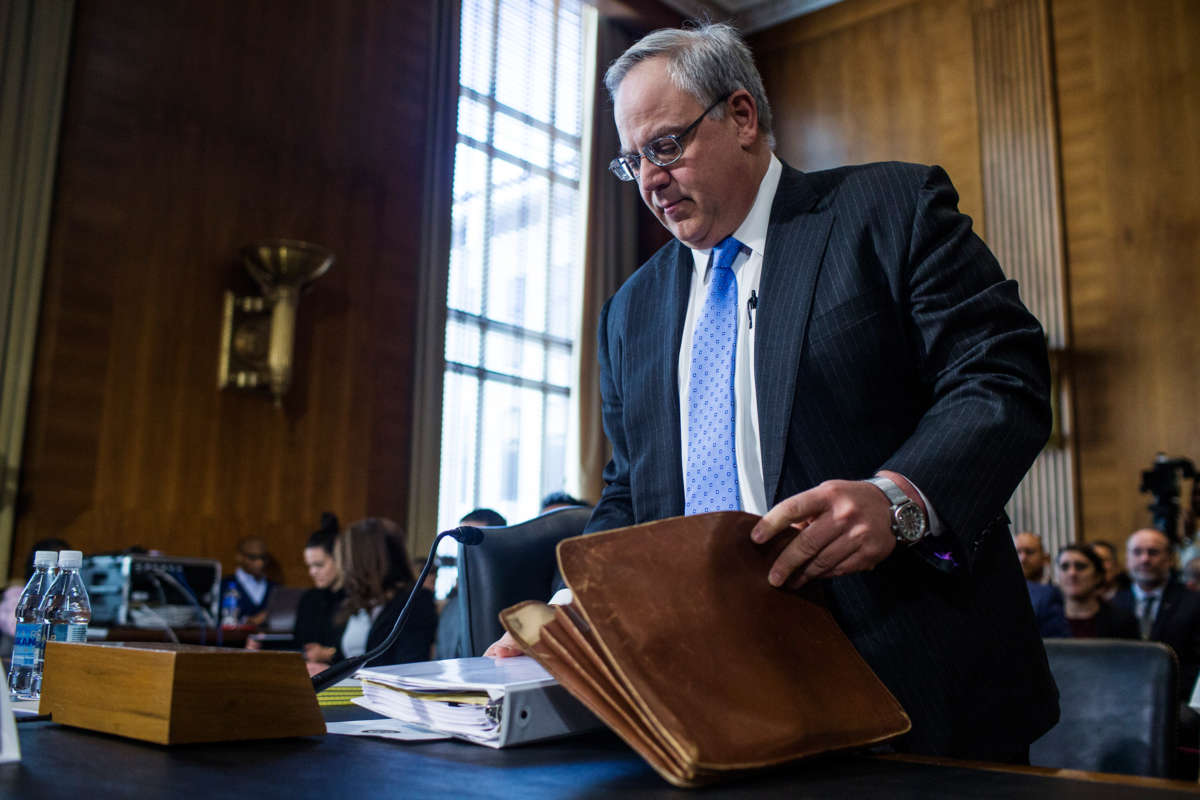 David Bernhardt packs papers into his briefcase during a hearing