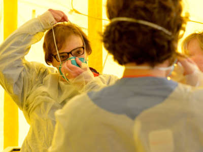 Hospital clinicians get into their protective equipment before testing patients for the coronavirus, COVID-19, at Newton-Wellesley Hospital in Newton, Massachusetts, on March 18, 2020.