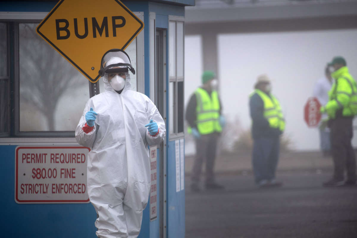 Health workers direct motorists at a COVID-19 drive thru testing location operated by Murphy Medical Associates at Cummings Park on March 20, 2020, in Stamford, Connecticut.