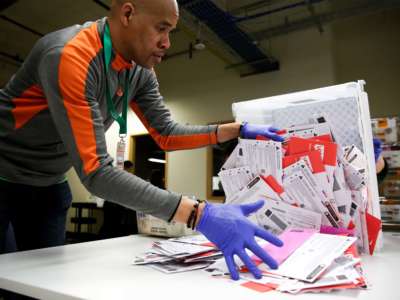 Election worker Erick Moss sorts vote-by-mail ballots for the presidential primary at King County Elections in Renton, Washington, on March 10, 2020.