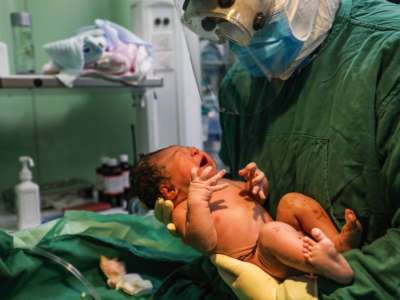 A medical staff member holds a newborn after a caesarean section at a gynaecology and obstetrics isolation ward for expectant mothers infected by the COVID-19 coronavirus in Xiehe hospital in Wuhan, in China's central Hubei province, March 7, 2020.