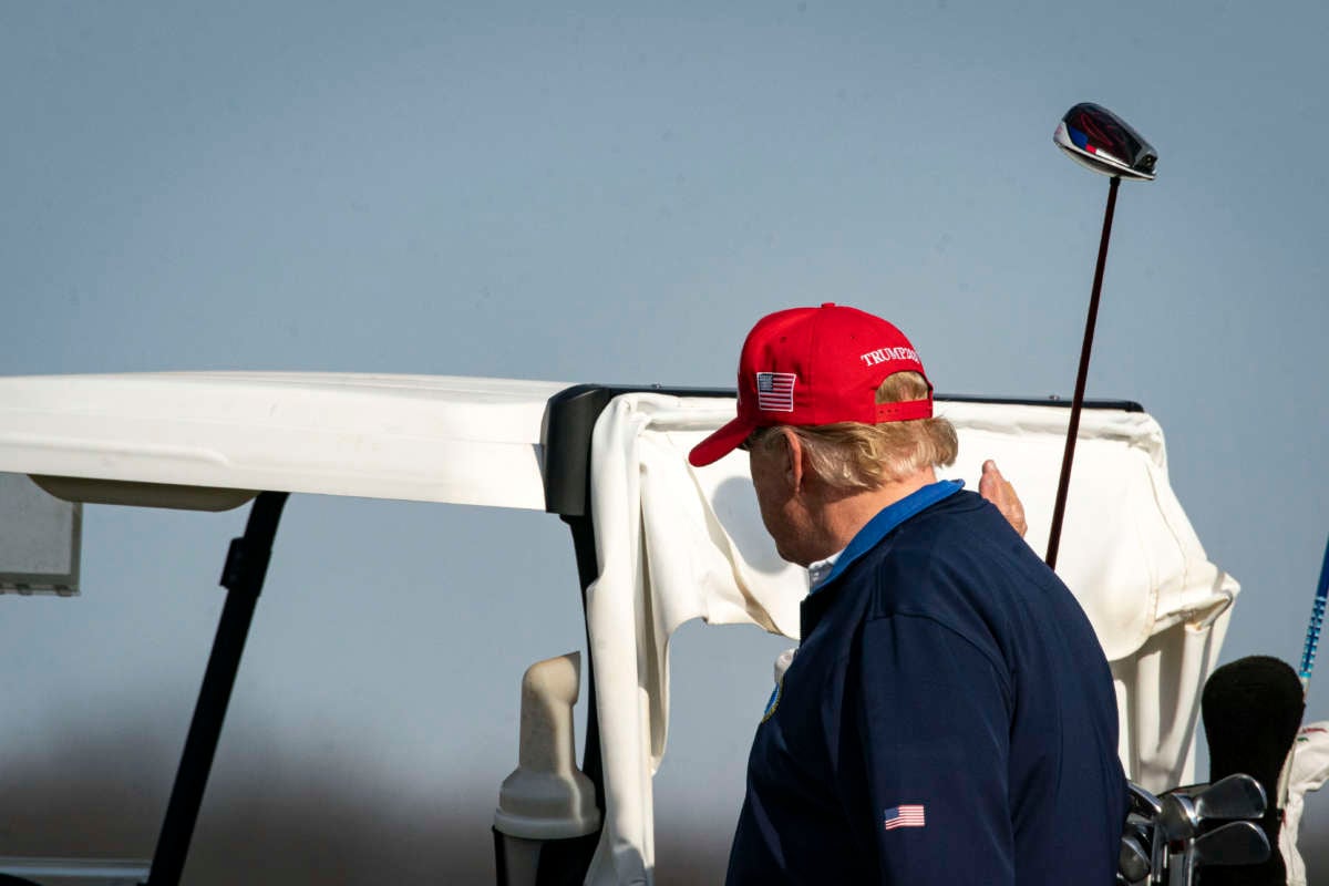 Donald Trump walks back to a golf cart