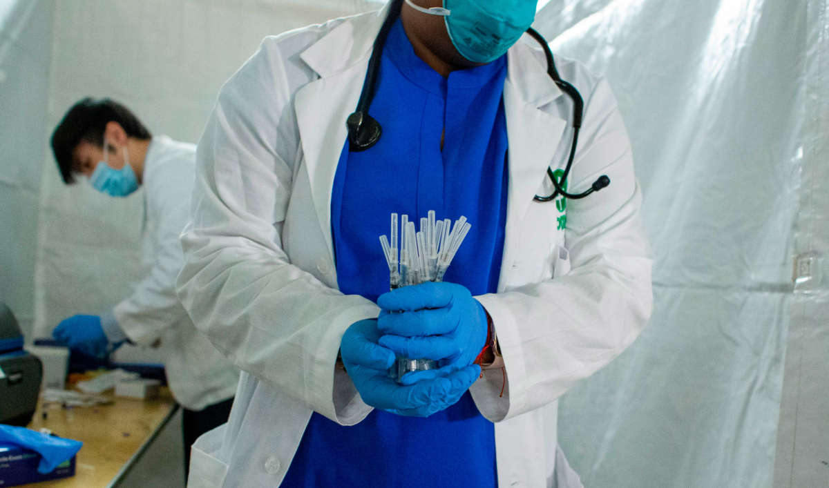 A health worker carries syringes to administer Pfizer Covid-19 vaccines at the opening of a new vaccination site at Corsi Houses in Harlem, New York, on January 15, 2021.