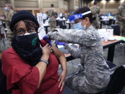 A member of the Illinois Air National Guard administers a COVID-19 vaccine at a mass vaccination center established at the Tinley Park Convention Center on January 26, 2021, in Tinley Park, Illinois.
