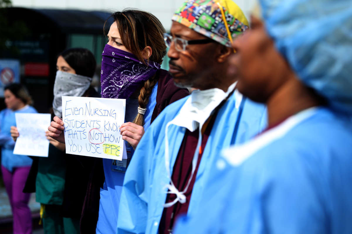 Alameda Health System nurses, doctors and workers hold signs during a protest in front of Highland Hospital on March 26, 2020, in Oakland, California.