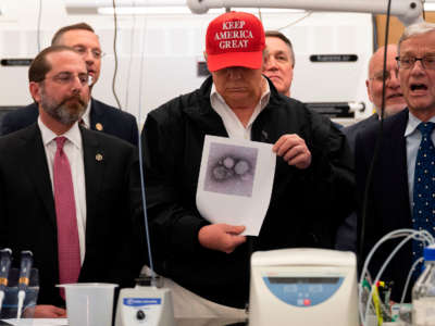 President Trump holds a picture of the coronavirus during a tour of the Centers for Disease Control and Prevention in Atlanta, Georgia, on March 6, 2020.
