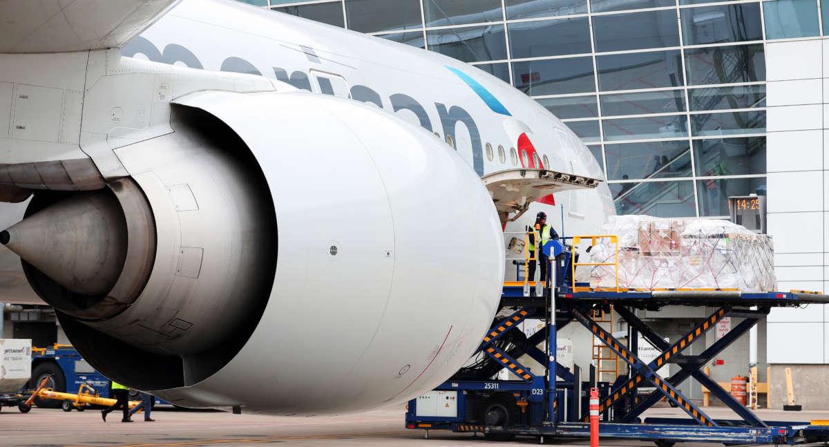 An American Airlines fleet services employee loads a cargo pallet on a Boeing 777-300 at Dallas / Fort Worth International Airport bound for Frankfurt am Main Airport in Germany during the COVID-19 pandemic on March 20, 2020, in Dallas, Texas.