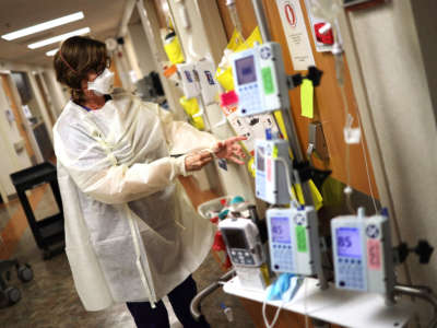 A nurse in the Intensive Care Unit of MedStar St. Mary's Hospital dons personal protective equipment before entering a coronavirus patient's room, April 8, 2020, in Leonardtown, Maryland.