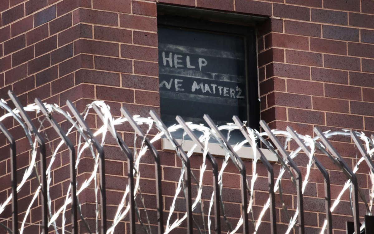 A sign pleading for help hangs in a window at the Cook County jail complex on April 9, 2020, in Chicago, Illinois.