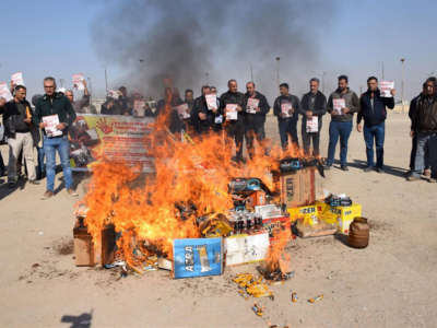 Following the invasion of Rojava, people burn Turkish products in Manbij.