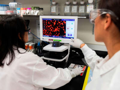 Dr. Sonia Maciejewski, right, and Dr. Nita Patel, director of antibody discovery and vaccine development, look at a sample of a respiratory virus at Novavax labs in Rockville, Maryland, on March 20, 2020, one of the labs developing a vaccine for COVID-19.