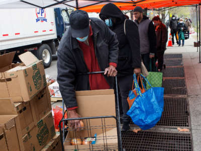 Local residents line up outside the food pantry Bed Stuy Campaign Against Hunger to receive free food during the COVID-19 pandemic on April 23, 2020, in the Bedford-Stuyvesant neighborhood of Brooklyn, New York.