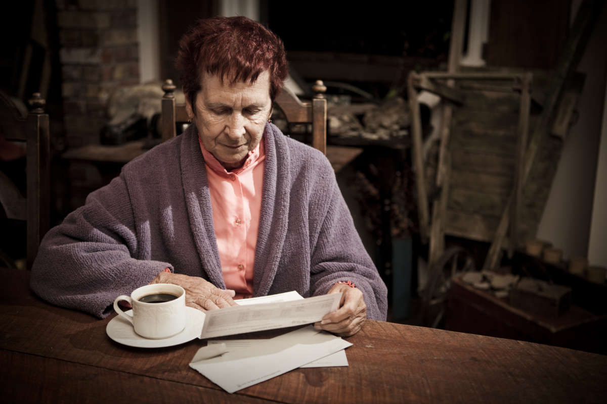 An elderely woman looks ar medical bills