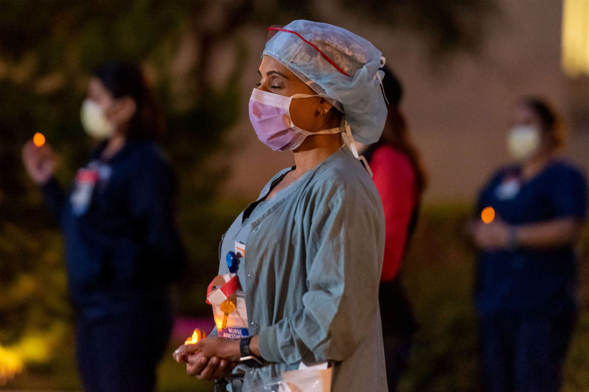 University of California, Irvine (UCI) nurses hold a candlelight vigil during the shift-change outside UCI Medical Center in Orange on April 20, 2020, to protest the lack of personal protective equipment for health care workers treating COVID-19 patients. The vigil also honored health care workers who have contracted COVID-19.