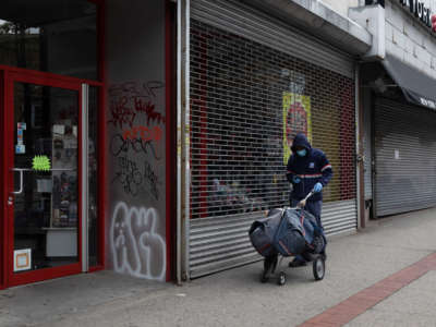 A postal worker delivers mail amid the coronavirus outbreak in New York City on April 9, 2020.