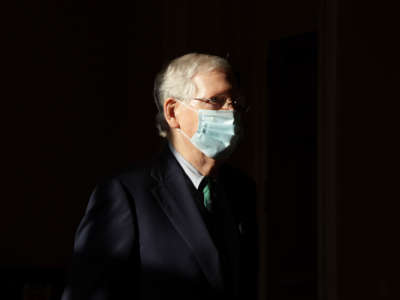 Senate Majority Leader Sen. Mitch McConnell wears a mask as he passes through a hallway at the U.S. Capitol, May 4, 2020, in Washington, D.C.