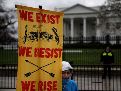 A protester holds a sign in front of the White House during a demonstration against the Dakota Access Pipeline on March 10, 2017, in Washington, D.C.