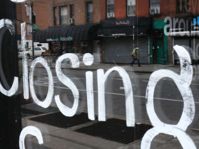A person walks past a closed business in Brooklyn on April 23, 2020, in New York City.