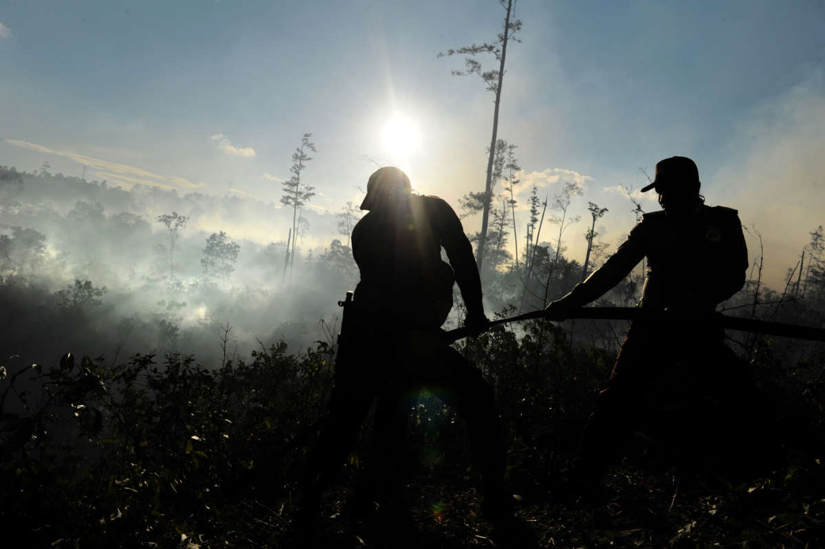 Rangers extinguish a fire in Seulawah, Indonesia, after the fire scorched hectares of pine trees, on October 10, 2016.