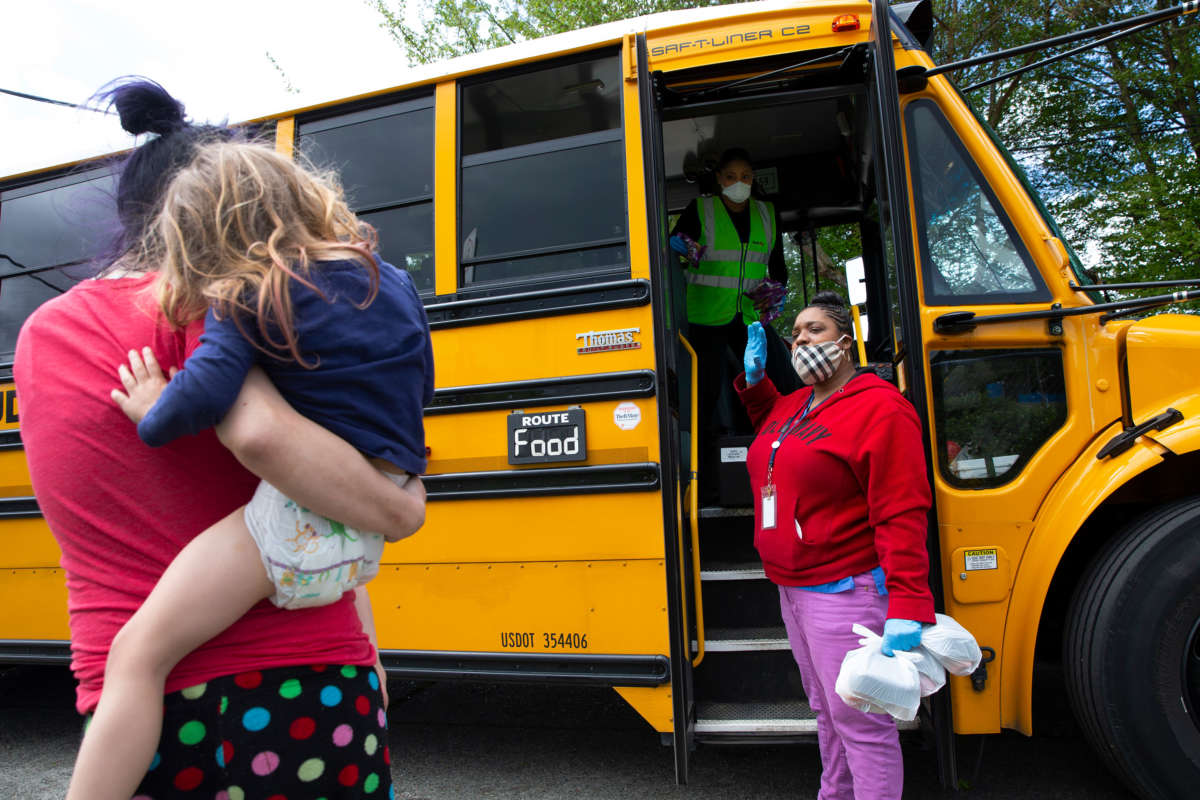 Bus driver Treva White and nutritionist Shaunté Fields deliver meals to children and their families on May 6, 2020, in Seattle, Washington.
