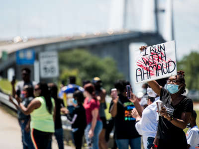 Demonstrators watch a parade of passing motorcyclists riding in honor of Ahmaud Arbery at Sidney Lanier Park on May 9, 2020, in Brunswick, Georgia. Arbery was shot and killed while jogging in the nearby Satilla Shores neighborhood on February 23.