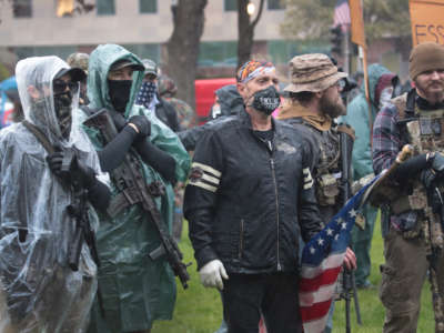 Demonstrators carrying guns hold a rally in front of the Michigan state capital building to protest the governor's stay-at-home order on May 14, 2020, in Lansing, Michigan.