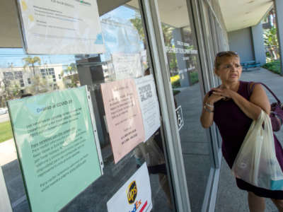 A woman looks on in dismay at the closed unemployment office