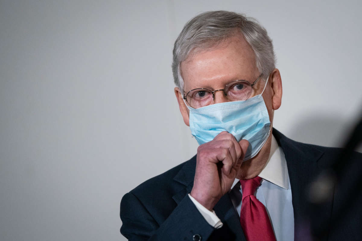 Senate Majority Leader Mitch McConnell puts on a mask after speaking to the press after a meeting with Republican Senators in the Hart Senate Office Building on Capitol Hill, May 19, 2020, in Washington, D.C.