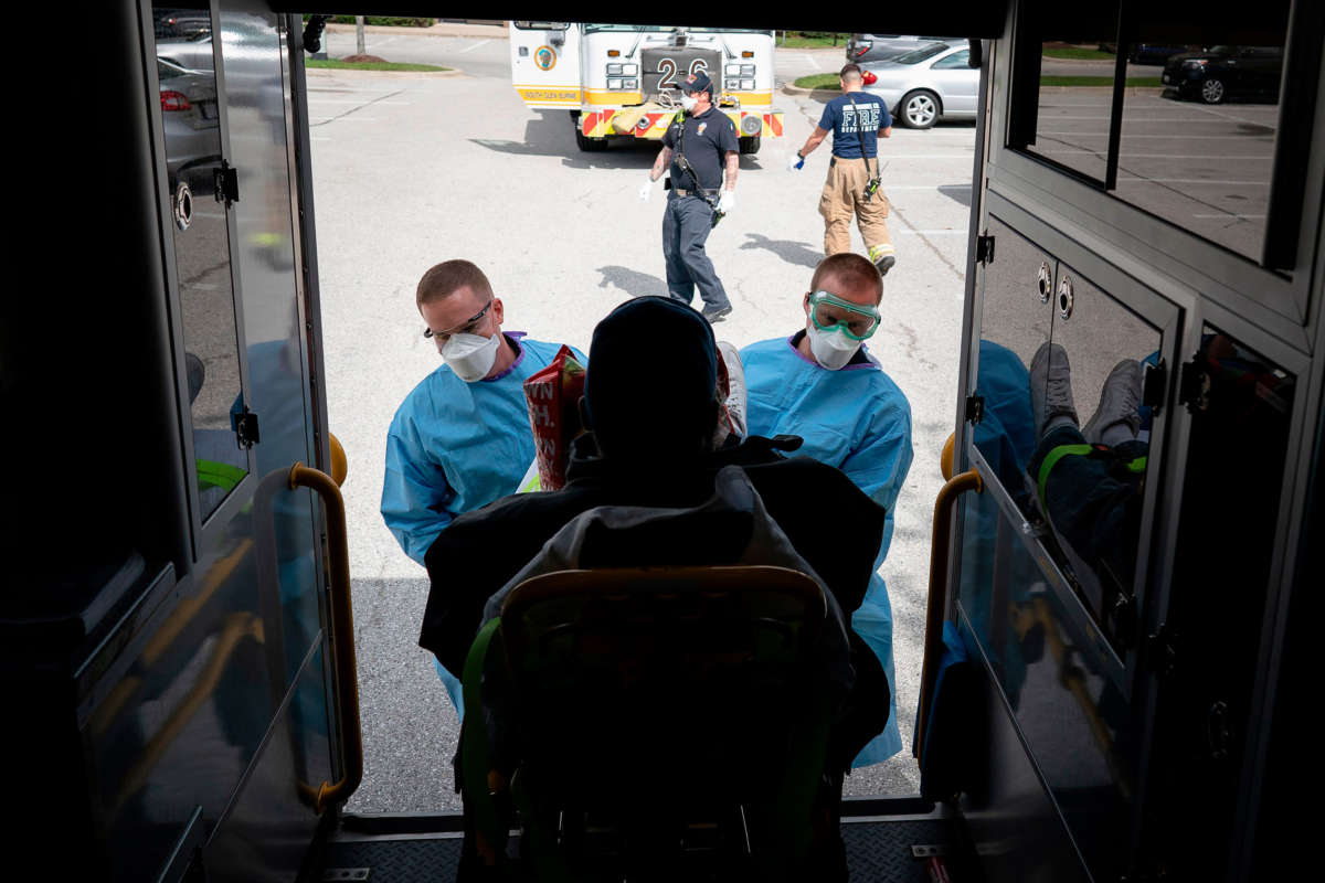 Paramedics and firefighters with Anne Arundel County Fire Department load a presumptive COVID-19 patient onto the ambulance on April 21, 2020, in Glen Burnie, Maryland.