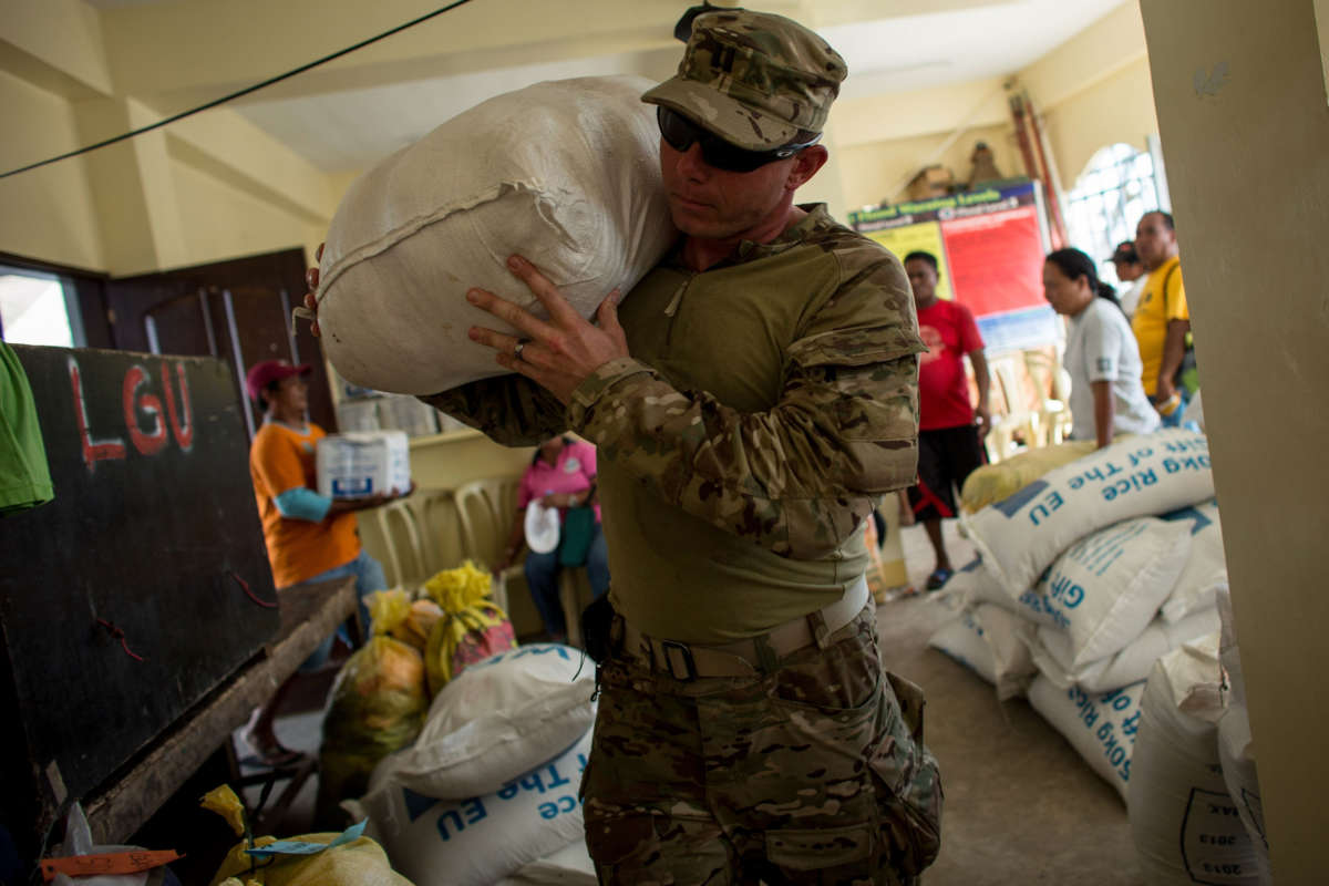 A soldier carries a large bag of food