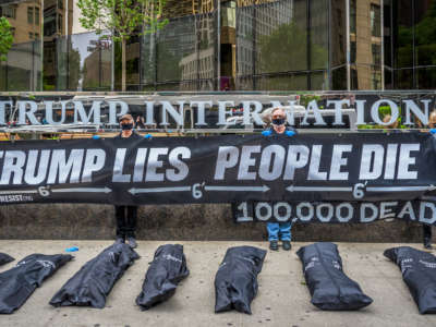Activists hold a banner that reads: TRUMP LIES, PEOPLE DIE and 100,000 DEAD behind body bags placed outside Trump International Hotel and Tower in New York City, May 24, 2020.