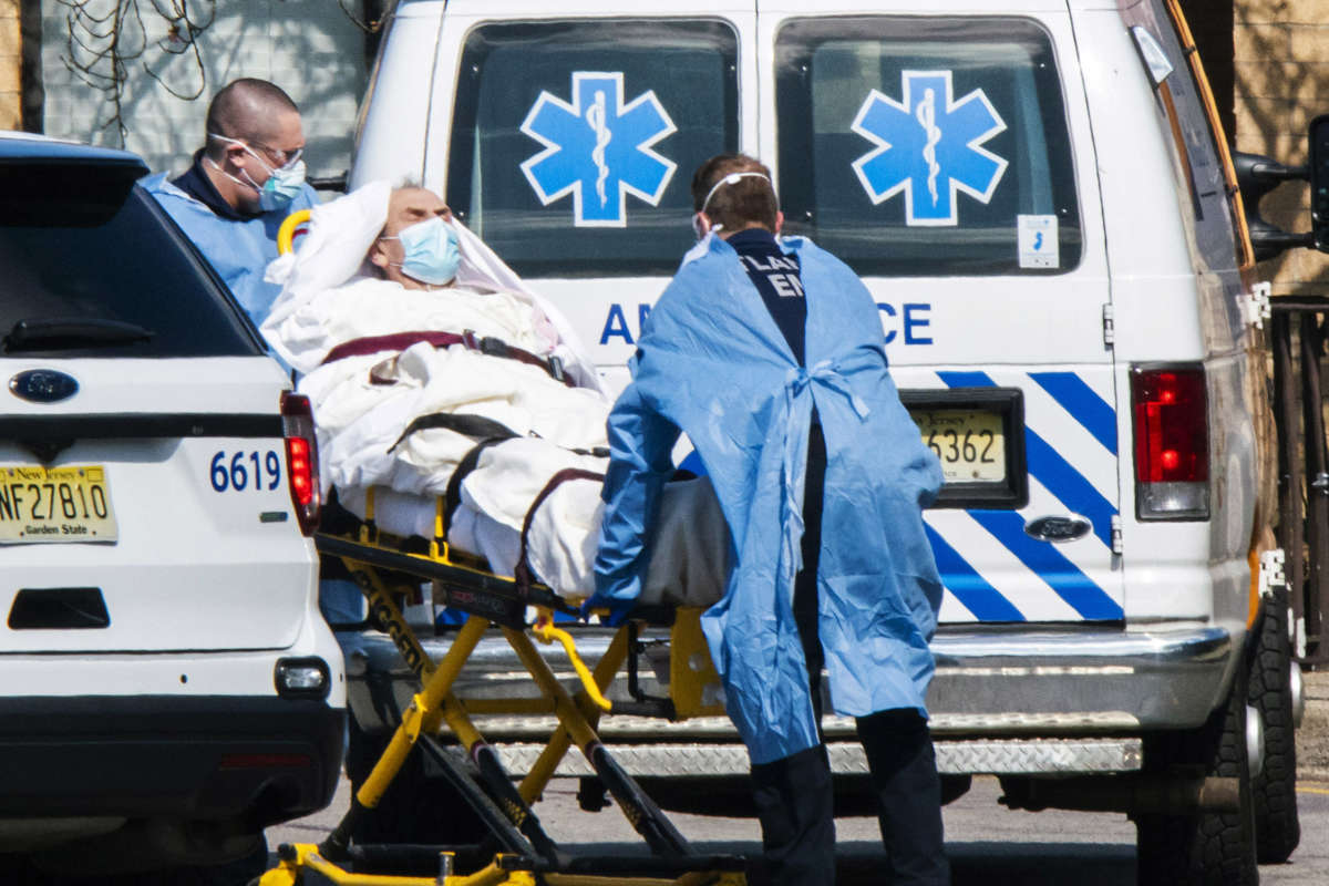 Medical workers load a patient from Andover Subacute and Rehabilitation Center into an ambulance while wearing masks and personal protective equipment on April 16, 2020, in Andover, New Jersey.
