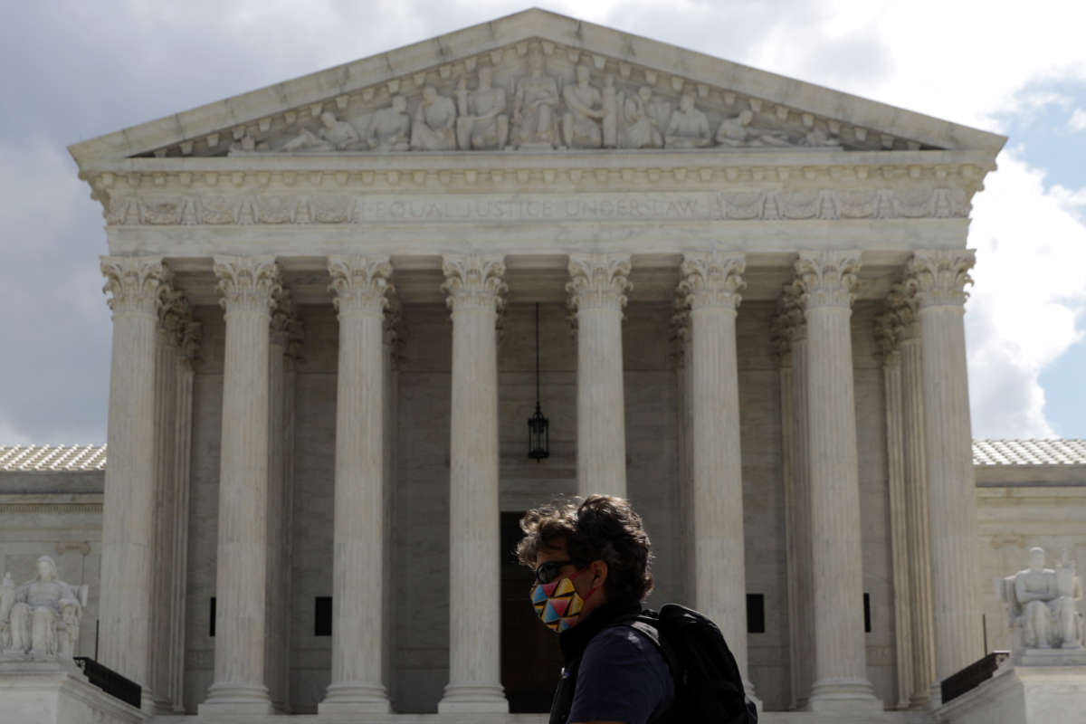 A pedestrian walks in front of the U.S. Supreme Court building on May 12, 2020, in Washington, D.C.
