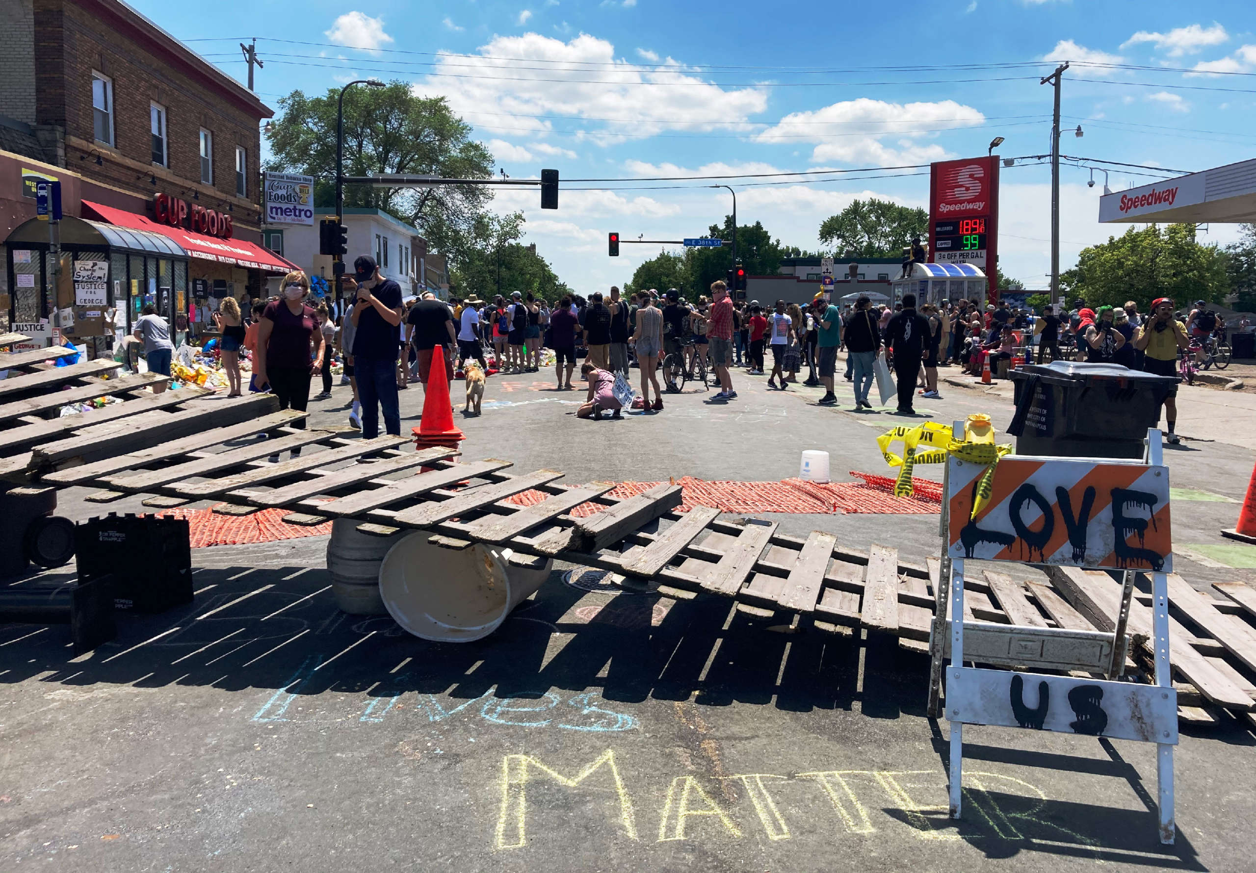 People gathered Monday at a vigil on the street corner in south Minneapolis where police killed George Floyd one week ago.
