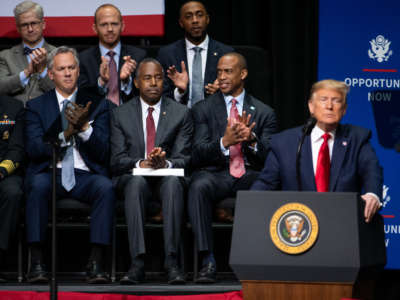 Housing and Urban Development Secretary Ben Carson, center, applauds with other guests as President Trump addresses the crowd during the Opportunity Now summit at Central Piedmont Community College on February 7, 2020, in Charlotte, North Carolina.