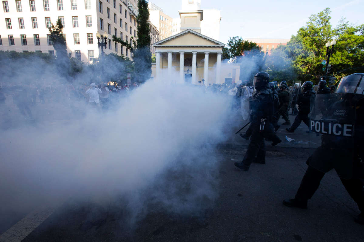 Police officers wearing riot gear push back demonstrators while shooting tear gas next to St. John's Episcopal Church outside of the White House, June 1, 2020, in Washington D.C., during a protest over the death of George Floyd.