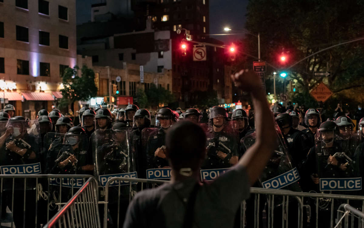A man protesting police brutality and systemic racism holds up his hands as they face police during a citywide curfew in New York City, on June 2, 2020.