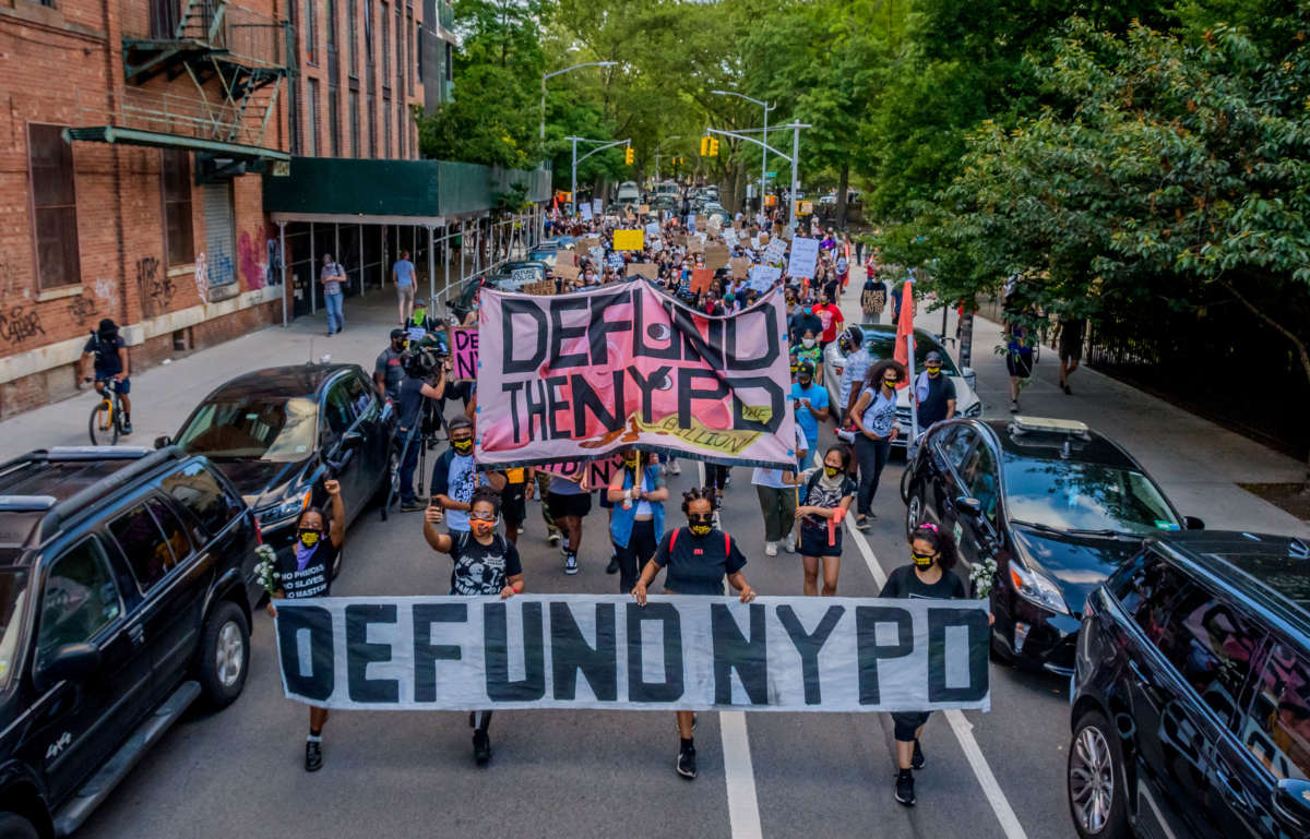 Protesters march down the streets of Williamsburg, New York, behind a giant Defund NYPD banner, June 7, 2020.