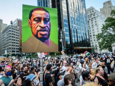 A painting of George Floyd is displayed at a massive protest