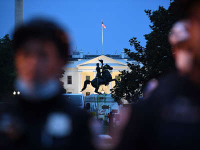 A row of police officers stand guard with the equestrian statue of former President Andrew Jackson behind, after protesters tried to topple it, at Lafayette square, in front of the White House, in Washington, D.C., on June 22, 2020.