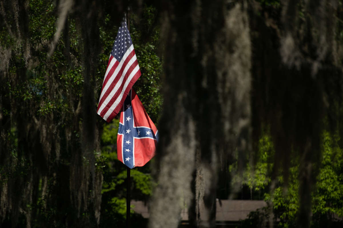 US and Confederate flags fly at a residence in the Fancy Bluff neighborhood on May 7, 2020, where Ahmaud Arbery lived in Brunswick, Georgia. Arbery was shot and killed by an armed father and son in the nearby Satilla Shores neighborhood on February 23, 2020.