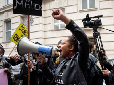 A protester with a megaphone addresses the crowd at a Black Lives Matter protest in front of the U.S. Embassy on June 5, 2020, in Vienna, Austria.
