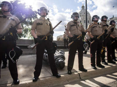 Members of the Minnesota State Patrol stand guard over a statue of Christopher Columbus which was toppled to the ground by protesters on the grounds of the State Capitol on June 10, 2020, in St. Paul, Minnesota.