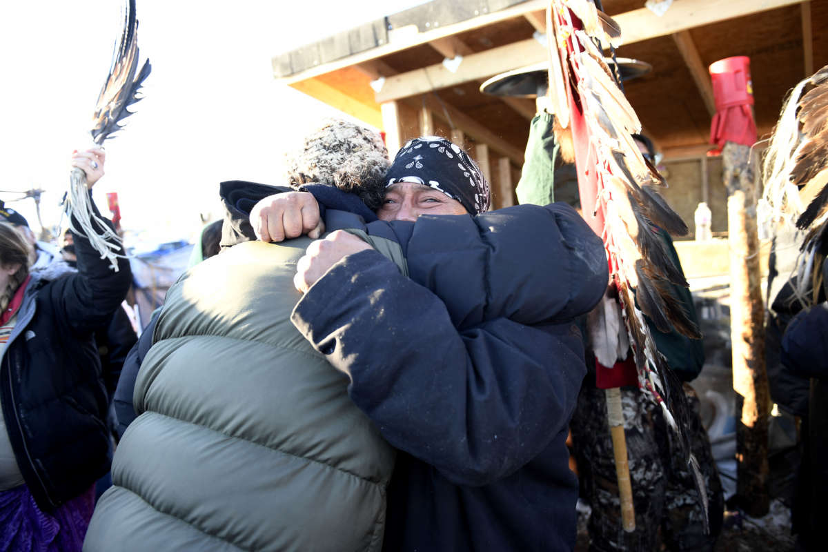 Two people tearfully embrace in cold weather gear